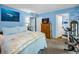 Comfortable bedroom with blue walls, wood dresser, queen size bed, and ensuite bath provides tranquil appeal at 9945 47Th N Ave # 210, St Petersburg, FL 33708