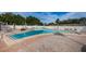 A community pool area surrounded by lounge chairs, umbrellas, and palm trees at 9945 47Th N Ave # 210, St Petersburg, FL 33708