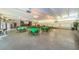 A large recreation room with multiple tables covered in green tablecloths at 9945 47Th N Ave # 210, St Petersburg, FL 33708