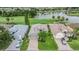 An aerial view of a well-manicured house, green lawn, and beautiful landscaping with a lake and golf course view at 10232 Buncombe Way, San Antonio, FL 33576