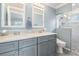 Charming bathroom with double sinks, a glass door shower, and elegant tiling at 10232 Buncombe Way, San Antonio, FL 33576