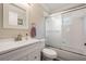 Clean bathroom with a white vanity, toilet and shower over tub with glass doors at 10232 Buncombe Way, San Antonio, FL 33576