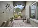 Inviting entrance to a home with a decorative tree, plants, and tiled floor at 10232 Buncombe Way, San Antonio, FL 33576