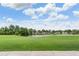 Scenic view of the lush green golf course with a serene lake under a bright, cloudy sky at 10232 Buncombe Way, San Antonio, FL 33576