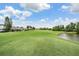 Picturesque view of the golf course featuring green fairways, a pond, and clear blue skies at 10232 Buncombe Way, San Antonio, FL 33576