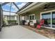 Relaxing screened-in patio with comfortable seating, ceiling fans, and brick flooring at 10232 Buncombe Way, San Antonio, FL 33576