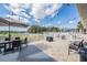 Outdoor patio with tables, chairs, umbrellas, and string lights overlooking the green golf course at 10232 Buncombe Way, San Antonio, FL 33576