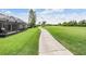 Scenic view of a paved walking path with views of golf course and a screened-in lanai at 10232 Buncombe Way, San Antonio, FL 33576
