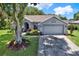 Well-maintained single-story home featuring a lush lawn, vibrant flowerbeds, and a two-car garage at 10314 Deepbrook Dr, Riverview, FL 33569