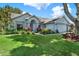 Landscaped front yard view of single story home with beautiful plantings and fresh green lawn at 10314 Deepbrook Dr, Riverview, FL 33569