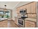 Open kitchen featuring wood cabinets, mosaic backsplash, and stainless steel appliances and hardware at 10314 Deepbrook Dr, Riverview, FL 33569