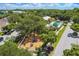 Aerial view of the community playground with mature trees and landscaping and nearby homes at 10422 Fenceline Rd, New Port Richey, FL 34655