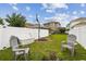 Spacious backyard with a basketball hoop, chairs, and a white fence, perfect for outdoor activities at 10422 Fenceline Rd, New Port Richey, FL 34655