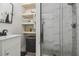 Bathroom features a glass shower, wood shelves and single vanity at 10422 Fenceline Rd, New Port Richey, FL 34655