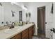Bathroom with dual sinks, wood cabinets, and neutral decor at 10422 Fenceline Rd, New Port Richey, FL 34655