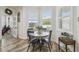 Bright dining area with wood-look floors, a round table with four chairs, and a garden view at 10422 Fenceline Rd, New Port Richey, FL 34655