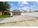 Long driveway leading to a two-car garage with a basketball hoop and a white fence at 10422 Fenceline Rd, New Port Richey, FL 34655