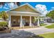 Exterior of the community center featuring a welcoming porch, lush landscaping, and parking area at 10422 Fenceline Rd, New Port Richey, FL 34655