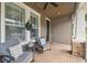 Charming covered front porch with comfortable seating and brick flooring, perfect for relaxing outdoors at 10422 Fenceline Rd, New Port Richey, FL 34655