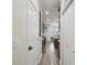 Hallway leading to kitchen with white walls, contrasting trim, luxury vinyl plank flooring, and modern appliances at 10422 Fenceline Rd, New Port Richey, FL 34655