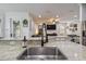 Kitchen island featuring granite countertops, stainless sink, faucet, and an open view into the living space at 10422 Fenceline Rd, New Port Richey, FL 34655