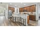Modern kitchen with stainless steel appliances, wooden cabinets, granite countertops, and seating at the breakfast bar at 10422 Fenceline Rd, New Port Richey, FL 34655
