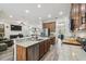 Open-concept kitchen featuring stainless steel appliances, granite countertops, and seamless flow into the living room at 10422 Fenceline Rd, New Port Richey, FL 34655