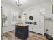 Bright kitchen features an island with butcher block top, built-in cabinets, and wood-look flooring at 10422 Fenceline Rd, New Port Richey, FL 34655