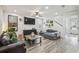 Living room featuring hardwood flooring, a ceiling fan, and stylish furniture at 10422 Fenceline Rd, New Port Richey, FL 34655