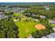 Aerial view of a community park including sports fields and surrounding homes in a lush, green neighborhood at 10422 Fenceline Rd, New Port Richey, FL 34655