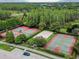 Aerial shot of community tennis, basketball and volleyball courts, ideal for social sports and recreation at 10422 Fenceline Rd, New Port Richey, FL 34655