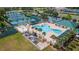 Aerial view of community pool with tennis courts, playground, and covered seating areas at 1044 Kennewick Ct, Wesley Chapel, FL 33543