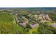 Aerial view of a condo complex surrounded by lush trees at 1044 Kennewick Ct, Wesley Chapel, FL 33543