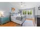 Bright bedroom featuring a metal bed frame, wood floors, a ceiling fan, and natural lighting at 1044 Kennewick Ct, Wesley Chapel, FL 33543