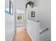 Bright hallway with hard wood floors, white walls, and an open doorway to a living space at 1044 Kennewick Ct, Wesley Chapel, FL 33543