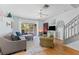 Inviting living room with wood floors, ceiling fan, comfortable seating and sliding glass door to the backyard at 1044 Kennewick Ct, Wesley Chapel, FL 33543