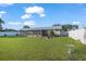 Spacious backyard with lush green grass, a screened-in porch, and a charming fire pit area at 11226 Murraysville Dr, Spring Hill, FL 34609