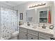 Updated bathroom featuring double sinks, modern fixtures, and a shower with a floral curtain at 11226 Murraysville Dr, Spring Hill, FL 34609