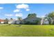 Inviting home exterior featuring a well-manicured lawn, metal roof, and lush landscaping, creating curb appeal at 11226 Murraysville Dr, Spring Hill, FL 34609
