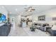 Spacious living area with modern furniture, stylish accents, a ceiling fan, and an open layout leading to the kitchen at 11403 Velvet Apricot Dr, Land O Lakes, FL 34638