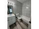 Updated bathroom featuring tiled shower with tub, new white vanity and wood-look flooring at 1215 Windsor Cir, Brandon, FL 33510