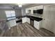 Modern kitchen featuring stainless steel appliances, sleek black countertops, and stylish wood-look flooring at 1215 Windsor Cir, Brandon, FL 33510