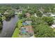 Aerial view showcases homes along a tranquil canal with lush greenery and neighborhood streets at 1286 Stony Brook Ln, Dunedin, FL 34698