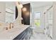 Elegant bathroom featuring a modern vanity, round mirror and sleek fixtures at 1286 Stony Brook Ln, Dunedin, FL 34698