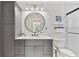 Modern bathroom featuring gray vanity, round mirror, and tiled walk-in shower at 1286 Stony Brook Ln, Dunedin, FL 34698