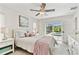 Bright bedroom with a ceiling fan, neutral decor, and view of the backyard pool at 1286 Stony Brook Ln, Dunedin, FL 34698