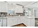 Bright white kitchen with stainless steel appliances, gray backsplash, and wood-look floors at 1286 Stony Brook Ln, Dunedin, FL 34698