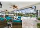 Inviting screened-in patio with wicker seating, ceiling fans, and views of the pool at 1286 Stony Brook Ln, Dunedin, FL 34698