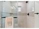 Beautiful shower with decorative tile, and glass door in this updated bathroom at 1286 Stony Brook Ln, Dunedin, FL 34698
