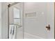 Updated shower showcasing a niche, glass door and modern white subway tile at 1286 Stony Brook Ln, Dunedin, FL 34698